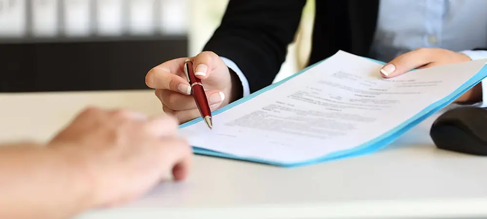 Persona firmando documentos para formalizar su emprendimiento y darle estructura legal.