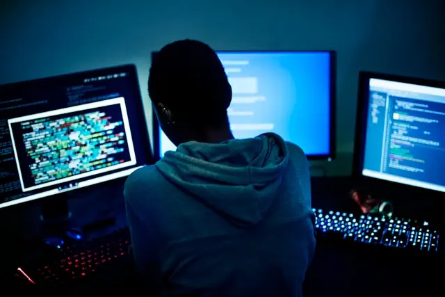 un hombre frente a varios monitores