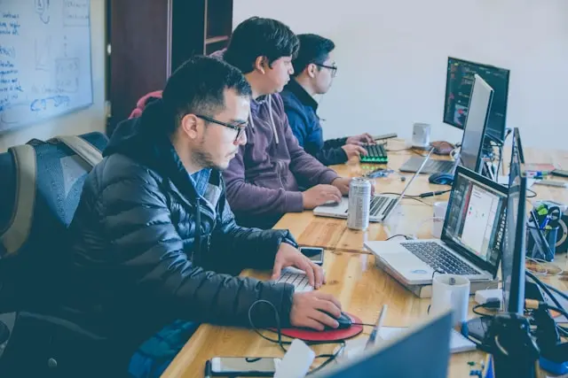 varias personas trabajando frente a laptops