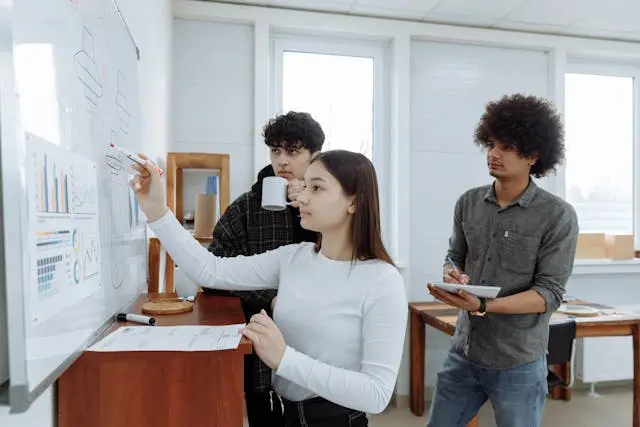 tres personas escribiendo en una pizarra
